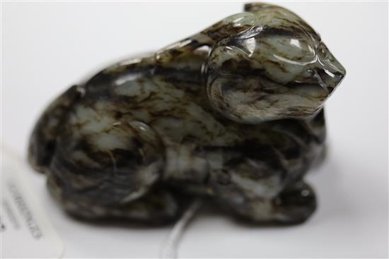 A Chinese pale grey and black jade recumbent figure of a lion-dog, length 8.3cm